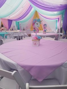 there is a pink and purple table cloth on the table