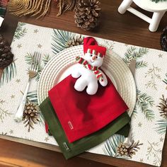 a christmas place setting with a snowman napkin holder