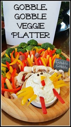 a platter filled with vegetables and veggies on top of a wooden plate