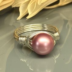 "Handmade Rose Swarovski Pearl and Sterling Silver, Yellow or Rose Gold Filled Wire Wrapped Ring; Custom Made to Size Looking for a delicate and feminine piece of jewelry that adds a touch of elegance to any outfit? This beautiful Rose Pink Swarovski Crystal Pearl Wrap Ring is the perfect choice! Handcrafted with care, this stunning ring features a lustrous Swarovski crystal pearl in a soft rose pink hue, wrapped securely in your choice of wire for the band. Swarovski crystal pearls are a premiu Nickel-free Pink Rings For Anniversary, Adjustable Pink Gold Jewelry For Anniversary, Adjustable Pink Gold Jewelry For Anniversaries, Nickel-free Pink Jewelry For Anniversary, Elegant Nickel-free Pink Ring, Nickel-free Pink Rings For Weddings, Rose Gold Wire Wrapped Rings For Wedding, Rose Gold Wire Wrapped Wedding Rings, Anniversary Rose Gold Wire Wrapped Jewelry