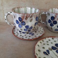 three cups and saucers with blue flowers on them