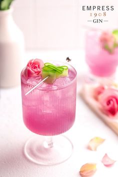 the pink cocktail is garnished with flowers