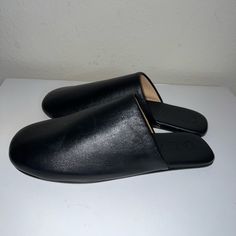 Butter Soft All Leather New Without Box Mules Chic Black Slip-on Slippers, Black Slip-on Flats With Rubber Sole, Black Slip-on Loafers With Leather Lining, Black Leather Slip-on Mules, Sleek Flats With Branded Insole And Closed Toe, Sleek Closed Toe Flats With Branded Insole, Sleek Synthetic Slip-on Mules, Black Faux Leather Loafers With Rubber Sole, Black Calf Leather Almond Toe Shoes