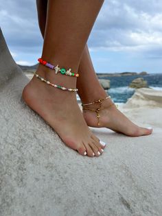 Add a touch of unique style to your summer wardrobe with these stunning handmade ankle bracelets! The first one boasts a colorful array of beads in different shapes, accented by white coral beads, gold metal parts, and a round evil eye charm in green color for added protection and good luck. The second bracelet features luminous white freshwater pearls, alongside vibrant colorful beads and gold metal parts, for an elegant yet playful look. Both bracelets are fully adjustable to fit any ankle siz Trendy Colorful Beads Anklets For Festival, Trendy Festival Anklets With Colorful Beads, Trendy Beaded Festival Anklets, Trendy Beaded Anklets For Festival, Bohemian Colorful Beads Anklet For Vacation, Beaded Bracelets For Beach Festival With Tiny Beads, Multicolor Tiny Beads Bracelets For Beach Season, Multicolor Tiny Beads Bracelet For Beach Season, Summer Gift Beaded Chain Anklets