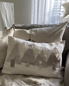 two pillows are sitting on a couch near a window