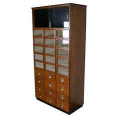 a tall wooden cabinet with many drawers