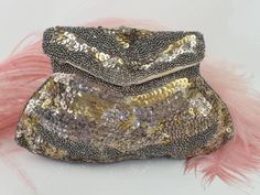 A stylish 1930s clutch purse.  Entirely embellished with tiny glass beads and sequins in tones of gold and silver. Some of the sequins have tarnished to a pale metallic pink.  There is a handle loop at the back.  Fastens with a press stud.  Lined with rayon. There is a handy little side pocket. Highly usable with due care.  Measurements: This purse does not fit a mobile phone.  The top- 12cm across Down- 12 cm The bottom- 19 cm across. Condition: Minimal missing embellishments. The sequins have Vintage Embellished Clutch Evening Bag, Antique Beaded Evening Bag For Party, Vintage Silver Embellished Evening Bag, Vintage Embellished Clutch For Party, Vintage Beaded Clutch For Events, Antique Clutch Evening Bag For Party, Silver Embellished Evening Bag For Celebration, Vintage Formal Evening Bag With Sequins, Silver Sequined Wedding Clutch