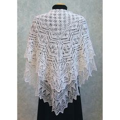 a white crocheted shawl on a mannequin