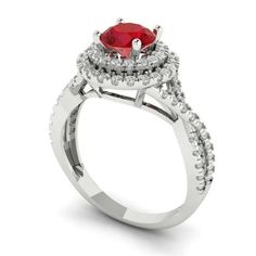 a ring with a red stone and white diamonds on the sides, set in 18k white gold