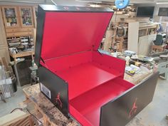 an open red box sitting on top of a table in a room filled with furniture