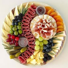 a platter filled with different types of cheeses and fruit