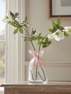 a vase filled with white flowers on top of a wooden table