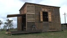 a small wooden building sitting on top of a lush green field