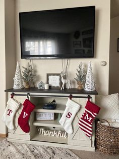 christmas stockings hanging from the mantle in front of a flat screen tv