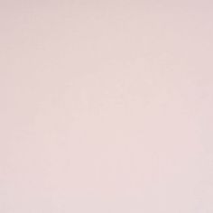 an airplane is flying in the sky on a pale pink background with no one around it