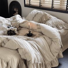 an unmade bed with two candles on it