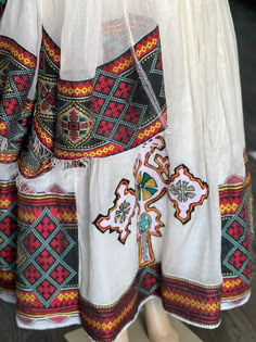 White Folk Dress With Woven Motifs, Folk Style White Dress With Traditional Drape, White Habesha Kemis With Woven Motifs For Festivals, Festival White Habesha Kemis With Woven Motifs, Folk Style Habesha Kemis For Festivals, Folk Style Habesha Kemis With Traditional Patterns For Festivals, Folk Style Tunic Dress With Traditional Patterns, Multicolor Habesha Kemis With Traditional Patterns, White Habesha Kemis With Woven Motifs For Traditional Ceremonies