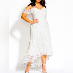 a woman in a white dress posing for the camera with her hands on her hips