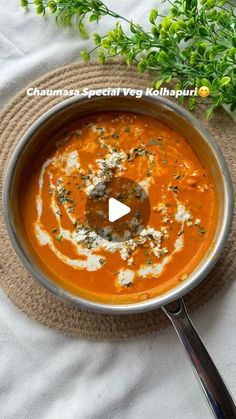 there is a bowl of soup on the table with a spoon in it and garnished with parsley