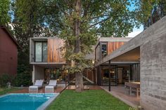 a house with a pool in the middle of it and trees on both sides of the building