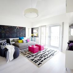 a living room filled with furniture and a chalkboard on the wall above it's windows