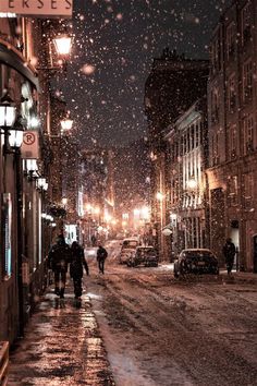 two people walking down a snowy street at night