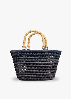 Our Lea tote is adorned with chic bamboo handles and will elevate any look. An interior pocket keeps your belongings secure and it’s roomy size easily fits your daily essentials. Handwoven open basket tote. Features bamboo handles. Measures 13.5” W x 8.2.5” H x 6.75” D with a 4.5” handle drop. Bamboo Handle Bag, Bucket Tote Bag, Rattan Dining, Bucket Tote, Straw Clutch, Basket Tote, Rattan Dining Chairs, Straw Tote Bag, South East Asia