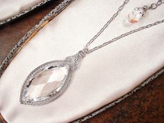 "I am so excited to be offering an exquisite antique Edwardian/Art Deco 1930s era rhodium plated filigree cut Austrian crystal pendant necklace. This will be as gorgeous with a pair of jeans and a tee as it will be with a Bridal gown. I can't tell you how much I love this antique treasure! It's designed like a camphor glass necklace of the period but has a cut glass crystal rather than camphor glass center. The pendant features an exquisite open backed thick high quality marquise shaped cut glas Antique Jewelry With Gemstone Accents For Formal Occasions, Exquisite Wedding Necklaces With Cabochon, Victorian Wedding Jewelry With Gemstone Accents, Classic Wedding Jewelry With Cabochon, Elegant Wedding Necklace With Cabochon, Victorian Cabochon Necklace For Wedding, Antique Wedding Jewelry With Gemstone Accents, Antique Jewelry With Gemstone Accents For Wedding, Antique Gemstone Accent Jewelry For Weddings