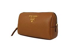 This Prada vanity case is so cute and coordinates beautifully with all of Prada's Vitello Daino leather collection! The size is perfectly compact to hold your essential cosmetic items that you may want to take with you on a trip or out for the day. Throw this in your handbag and store your items classically. Features a zip closure and gorgeous gold-tone Prada emblem on the front and a black lined interior.     Model: 1ND004  Cannella brown    Vitello Daino calfskin leather  Gold-tone hardware  P Luxury Brown Cosmetic Bag For Travel, Luxury Brown Cosmetic Bag For Daily Use, Luxury Brown Travel Cosmetic Bag, Luxury Leather Cosmetic Bag With Zipper Closure, Classic Compact Bag With Zipper Closure, Luxury Brown Cosmetic Bag With Removable Pouch, Elegant Brown Cosmetic Bag With Removable Pouch, Luxury Brown Rectangular Cosmetic Bag, Compact Leather Bags With Zipper Closure