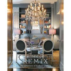 the inside of a room with chandelier and chairs in it, next to an open bookcase