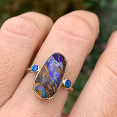 A full spectrum of colors is present in this Australian Boulder Opal accented by two opal doublets in 14k yellow gold with Emily's hand hammered gold band Approximate stone size: 18mm x 10mm Approx ct weight: 7.25cts Mohs Stone Hardness: 7-7.5 This one of a kind piece is handmade to order in Emily's Hudson Valley studio. If you have questions about sizing, shipping or need help deciding please reach out to us! Opal And Turquoise Ring, Birthstone Stacking Rings, Imperial Topaz, Australian Boulder Opal, Hammered Gold, Diamond Shop, Full Spectrum, Australian Opal, London Blue Topaz