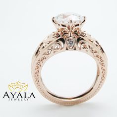 a close up of a ring with a diamond in the center and an intricate filigree design on the band