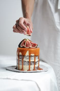 a person is decorating a cake with figs