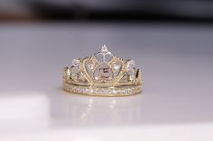 a gold crown ring with diamonds on it