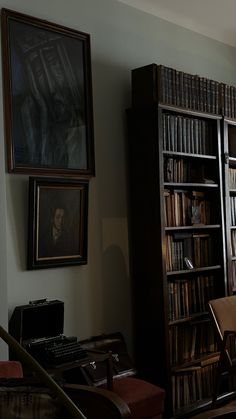 an old library with bookshelves and pictures on the wall