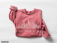 Discover the perfect gift for fans with our trendy New York City Skyline Sweatshirt. Its clean aesthetic and preppy NYC style make this shirt a must-have for anyone who loves the city's vibe! 𝐃𝐄𝐓𝐀𝐈𝐋𝐒 🌺 50% cotton, 50% polyester 🌺 Medium-heavy fabric (8.0 oz/yd² (271.25 g/m²) 🌺 Loose fit 🌺 Sewn-in label 🌺 Runs true to size 🌺 Mugs are 100% ceramic, dishwasher & microwave safe 𝐇𝐎𝐖 𝐓𝐎 𝐎𝐑𝐃𝐄𝐑 1) Select size and color 2) Select Quantity 3) Add to Cart 𝑵𝒆𝒆𝒅 𝒂 𝒔𝒊𝒛𝒆 𝒐𝒓 𝒄 New York City Sweatshirt, New York Sweatshirt, Aesthetic Preppy, Nyc Style, New York City Skyline, Clean Aesthetic, City Vibe, Nyc Fashion, Trendy Shirts