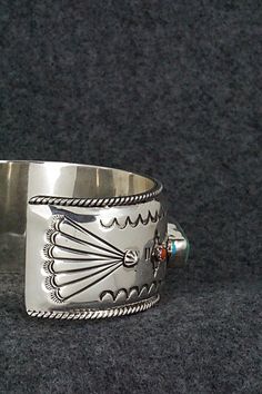 This stunning and substantial turquoise, coral and sterling silver bracelet was made by Navajo silversmith Emerson Delgarito. The inside is signed E. Delgarito and stamped sterling.Size: 5 3/8" (will fit up to a 6 1/2" wrist)Gap: 1 1/8"Length: 1 1/8"Free shipping on all orders! We ship with USPS and always include tracking. All orders ship within a day of payment.Returns are accepted up to 30 days after you receive your order. Just send us a message. Our shop offers cash back or store credit. Th Southwestern Sterling Silver Inlay Bracelet Gift, Southwestern Silver Multi-stone Bracelets, Southwestern Silver Multi-stone Bracelet, Artisan Silver Multi-stone Cuff Bracelet, Southwestern Silver Bracelet With Multi-stone, Silver Artisan Multi-stone Cuff Bracelet, Southwestern Polished Cuff Bracelet As Gift, Southwestern Style Bracelet With Polished Finish, Native Jewelry