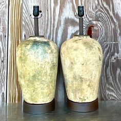 two vases sitting on top of a wooden table next to each other, one is yellow and the other is brown