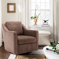 a living room with a chair, table and lamp in front of a large window