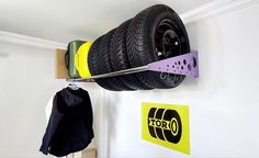 a car tire hanging on the wall next to a pair of skis and a bag