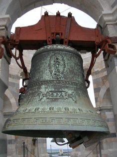 the large bell is hanging from the ceiling