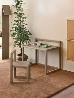 a living room with a chair, table and potted plant on the carpeted floor