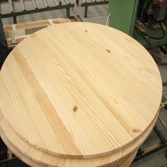 a round wooden table sitting on top of a pallet next to other pieces of wood