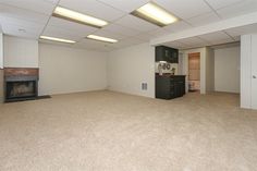 an empty room with a fireplace and cabinets