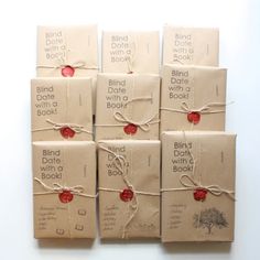 six books wrapped in brown paper and tied with twine, each containing a red button