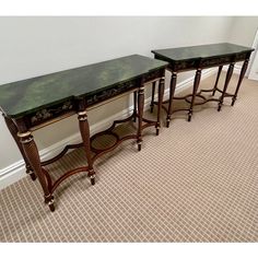 two green marble top tables sitting next to each other on carpeted floor with white walls