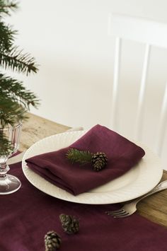 a place setting with pine cones and napkins