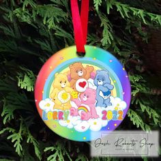 a colorful ornament hanging from a tree with teddy bears on it's side