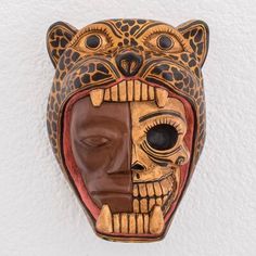 a wooden mask hanging on the wall