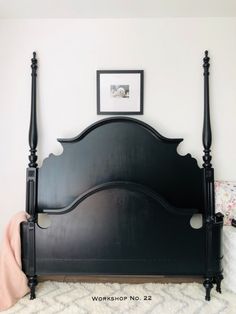 a bed with black headboard and foot board on top of white carpeted floor